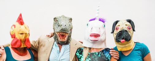 Happy family wearing different carnival masks - Crazy people having fun wearing on chicken, carlino, t-rex and unicorn mask - Concept of bizarre, humor and masquerade holidays lifestyle party photo