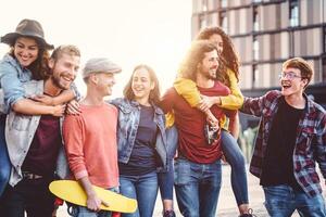 Group of young people having fun in the city center - Happy friends piggybacking while laughing and walking together outdoor - Friendship, millennial generation, teenager and youth lifestyle concept photo