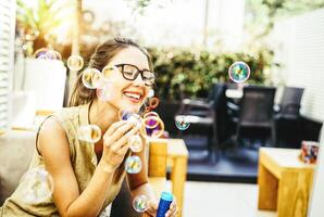 Playful young woman blowing party bubbles soap - ethereal in the backyard - Happiness, joy, girl childish concept photo