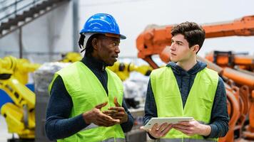 Multiracial engineers working in robotic factory - Tech industry concept photo