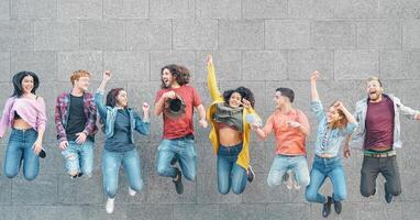 Happy friends jumping together outdoor - Millennial young people having fun celebrating together outside - Concept of friendship, celebration party and youth lifestyle photo