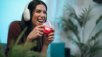 joven mujer jugando en línea vídeo juegos a hogar - juventud personas fanático a nuevo tecnología juego de azar entretenimiento foto