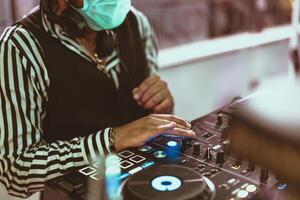 Dj mixing music wearing face mask during covid19 - Party nightlife concept photo