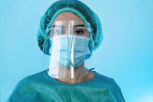 Young female doctor wearing personal protective equipment during corona virus pandemic - Health care worker concept photo