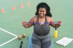 Curvy Afro woman doing workout  exercises session - Young African female having fun training outdoor - Sporty people lifestyle concept photo