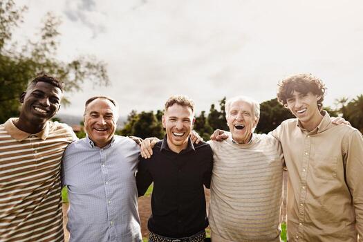 Happy multigenerational group of men with different ages and ethnicities having fun smiling in front of camera at park photo