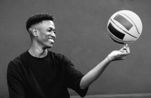 Happy young African man playing basketball outdoor - Urban sport lifestyle concept - Black and white editing photo