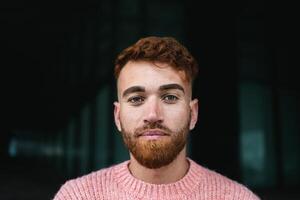 Portrait of young man with red hair looking at the camera photo