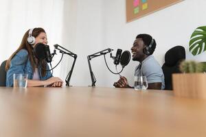 Multiracial people recording a podcast using microphone and headphones from home studio photo