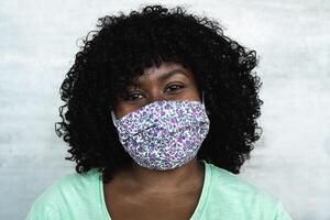 Happy African woman portrait - Afro girl wearing protective face mask for preventing spread of corona virus - Health care people concept photo