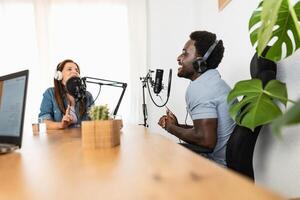 Multiracial people recording a podcast using microphone and laptop from home studio photo