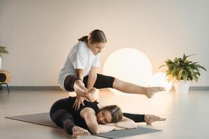 Mom and teenage daughter do gymnastics together in the fitness room. A woman and a girl train in the gym photo