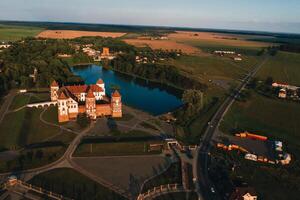 Mir orange castle with spiers near the lake a top view in Belarus in Nesvizh photo