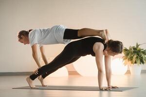 Mom and teenage daughter do gymnastics together in the fitness room. A woman and a girl train in the gym photo