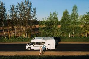 A couple is standing on the road near their motorhome at dawn photo