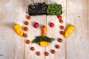 The face of a man made of sliced vegetables on a wooden background photo