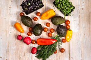 Assorted vegetables lying on a wooden table photo