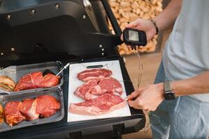 Preparation for Cooking meat on an open grill with temperature check photo