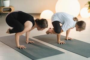 Mom and teenage daughter do gymnastics together in the fitness room. A woman and a girl train in the gym photo