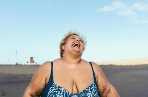 a woman laughing on the beach photo