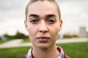 Shaved head girl looking at camera portrait photo