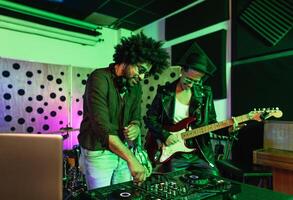 joven contento personas jugando música con DJ mezclador y guitarra en casa producción estudio - juventud músico entretenimiento concepto foto