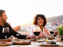 a group of people enjoying wine and food at a table photo