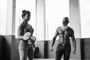 a man and woman are working out with dumbbells photo