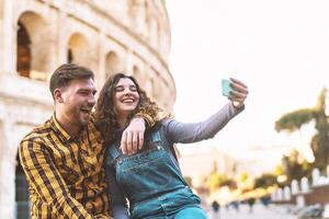 a couple taking a selfie in front of the colosseum photo