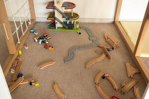 A scattered wooden road construction kit on the floor. Child's play photo