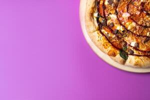 Delicious large pizza with bacon and spinach on a pink background photo