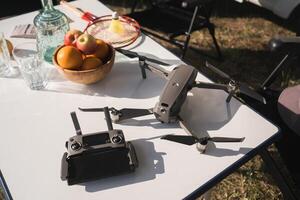 the quadcopter and the remote control are on the table near the campsite photo