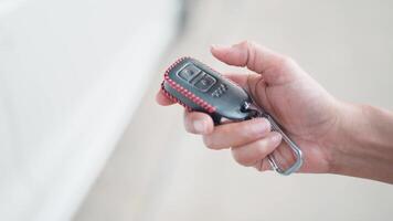 Locking and unlocking the car with the remote key When the car key button is pressed, the light will flash when the door is opened or closed. Female hand uses remote control key video