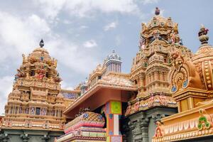 Part of a beautiful and colorful Indian temple in Mauritius Island. Close-up on sculptures and statues of Indian deities photo