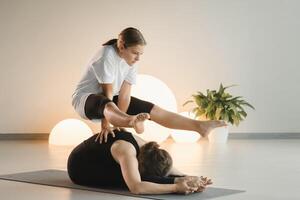 Mom and teenage daughter do gymnastics together in the fitness room. A woman and a girl train in the gym photo