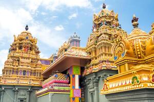 Part of a beautiful and colorful Indian temple in Mauritius Island. Close-up on sculptures and statues of Indian deities photo