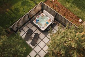 Top view of a family relaxing in an outdoor hot tub in summer photo