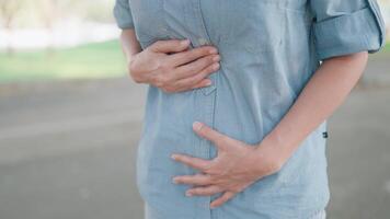 vrouw lijden van maag- spasmen buik pijn buiten benadrukt jong vrouw masseren haar maag met buik pijn. gastritis, maag pijn of menstruatie- pijn, diarree. video