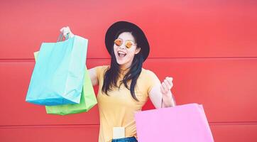 Asian fashion girl doing shopping in mall center - Happy Chinese woman having fun buying new clothes in vacation - Consumerism, people and youth lifestyle concept photo