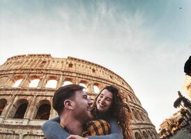 a couple is smiling in front of the colosseum photo