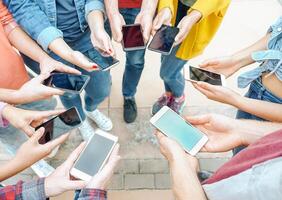 grupo de amigos utilizando su inteligente móvil Los telefonos - milenario joven personas fanático a nuevo tecnología tendencias - concepto de gente, Generacion z, tecnología, social medios de comunicación red y juventud estilo de vida foto