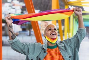 Young smiling woman holding rainbow flag symbol of Lgbtq social movement photo