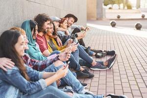 Group trendy friends using smart mobile phones outdoor - Millennial people having fun with new technology trends smartphone - Youth generation lifestyle and tech addiction social media concept photo