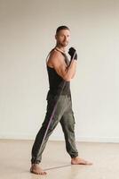 A man in black sportswear is engaged in strength fitness using a rubber loop indoors photo