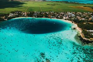 Aerial picture of the east coast of Mauritius Island. Beautiful lagoon of Mauritius Island shot from above. Boat sailing in turquoise lagoon photo