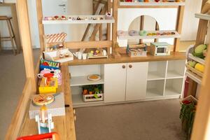 Wooden children's play kitchen with dishes and artificial food photo