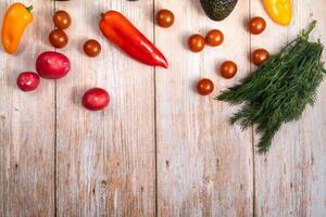 Assorted vegetables lying on a wooden table photo