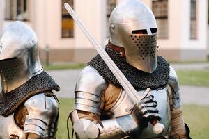 Two knights in armor on the background of a medieval castle.A medieval concept.Metallic texture photo