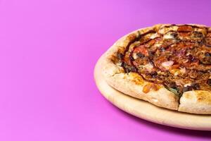 Delicious large pizza with bacon and spinach on a pink background photo