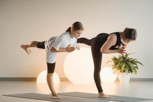 Mom and teenage daughter do gymnastics together in the fitness room. A woman and a girl train in the gym photo